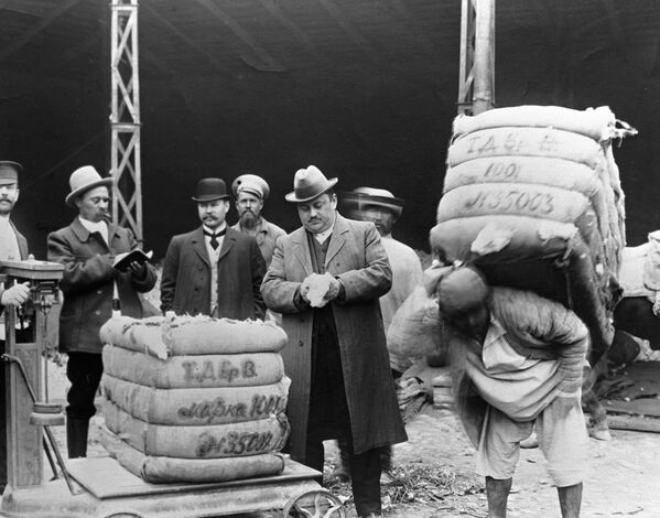 Тошкентдаги пахта тозалаш заводида пахтани тортиш. 1917 йилгача олинган фотосурат. Суратда кўрсатилган одам бир кунда қанча сумка кўтариб юрганини тасаввур қилиш қийин. Тошкентдаги пахта тозалаш заводида пахтани тортиш. 1917 йилгача олинган фотосурат. Суратда кўрсатилган одам бир кунда қанча сумка кўтариб юрганини тасаввур қилиш қийин. - Sputnik Ўзбекистон